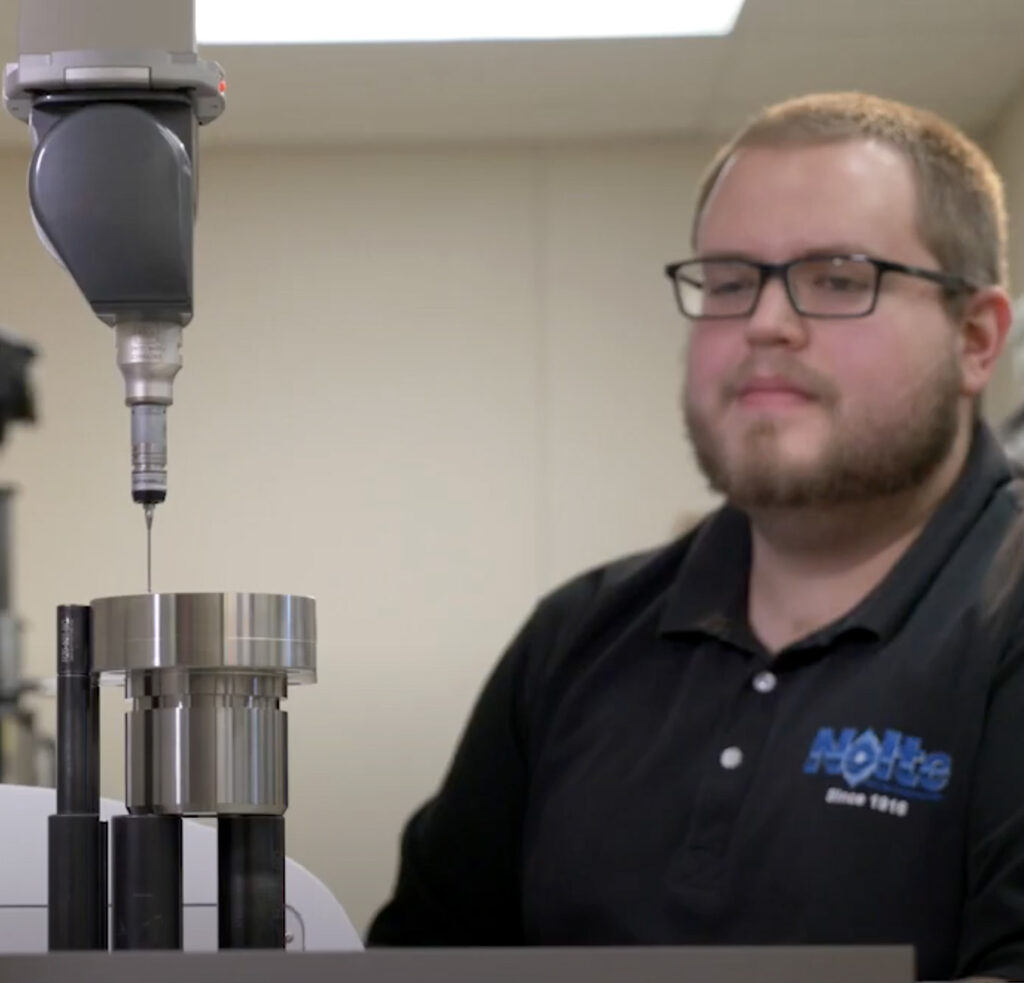 Man in machine shop working quality control job on CMM (Coordinate measuring machine)